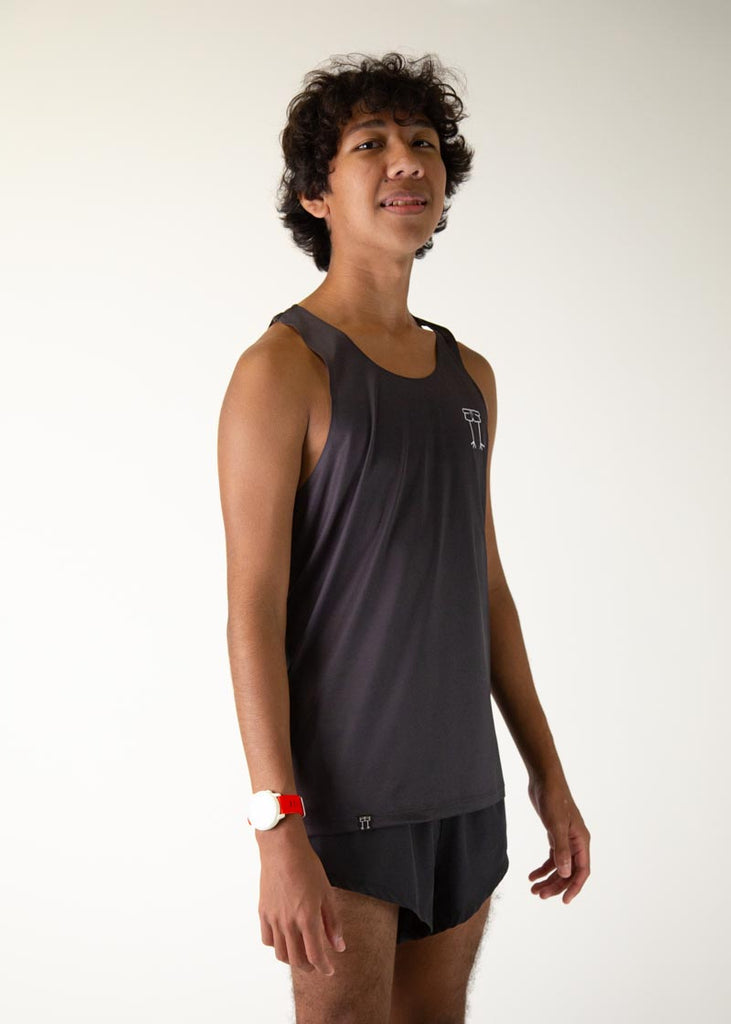 The model is a runner who is wearing Chicknlegs men's running performance singlet in the black design, facing right.