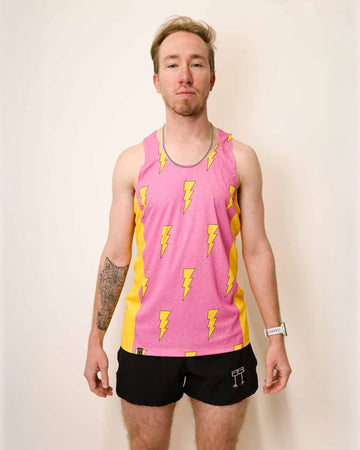 Runner is wearing ChicknLegs in the men's performance singlet that has yellow side panels. The material is lightweight and the print has yellow lightning bolts on it with a bright pink background.