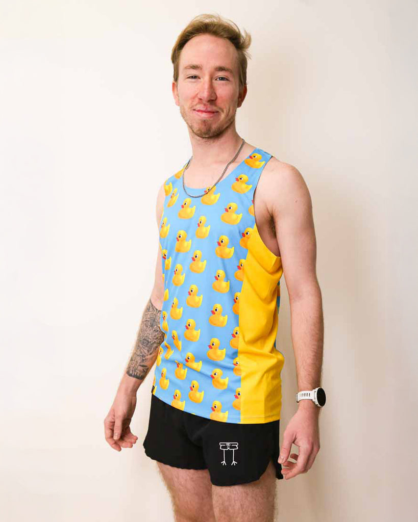 Runner is wearing ChicknLegs men's performance singlet with yellow side panels. The print has rubber duckys on it and a blue background.