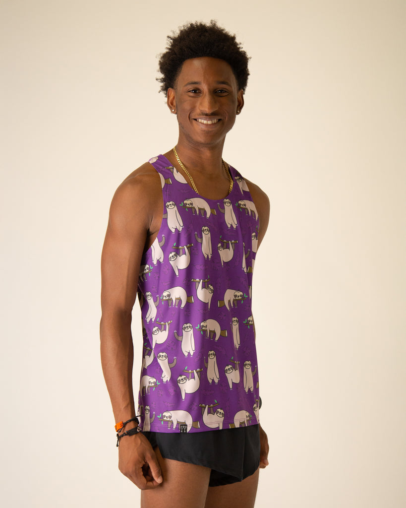 Runner is wearing ChicknLegs in the men's performance singlet in the sloth design. The print has sloths on it with tree branches and leaves on a purple background.