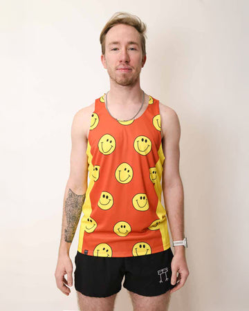 Runner is wearing ChicknLegs in the men's performance singlet with yellow side panels. The print has yellow smiley faces on it with an orange background.