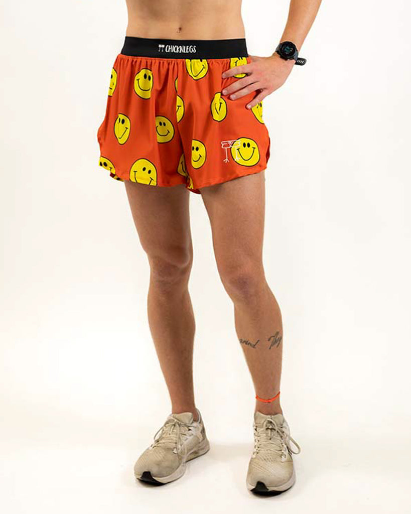 Runner is wearing ChicknLegs in the men's 4 in split running shorts in the smiley design. The print has yellow smiley faces on it on an orange background.