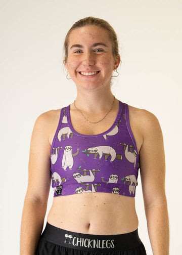 The model is a runner who is wearing Chicknlegs OG sports bra, in the sloth design, facing front. A close up is shown.