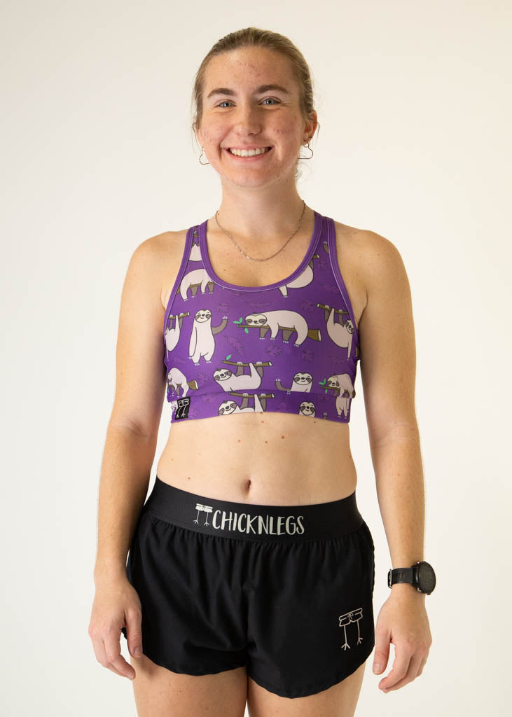 The model is a runner who is wearing Chicknlegs OG sports bra, in the sloth design, facing front.