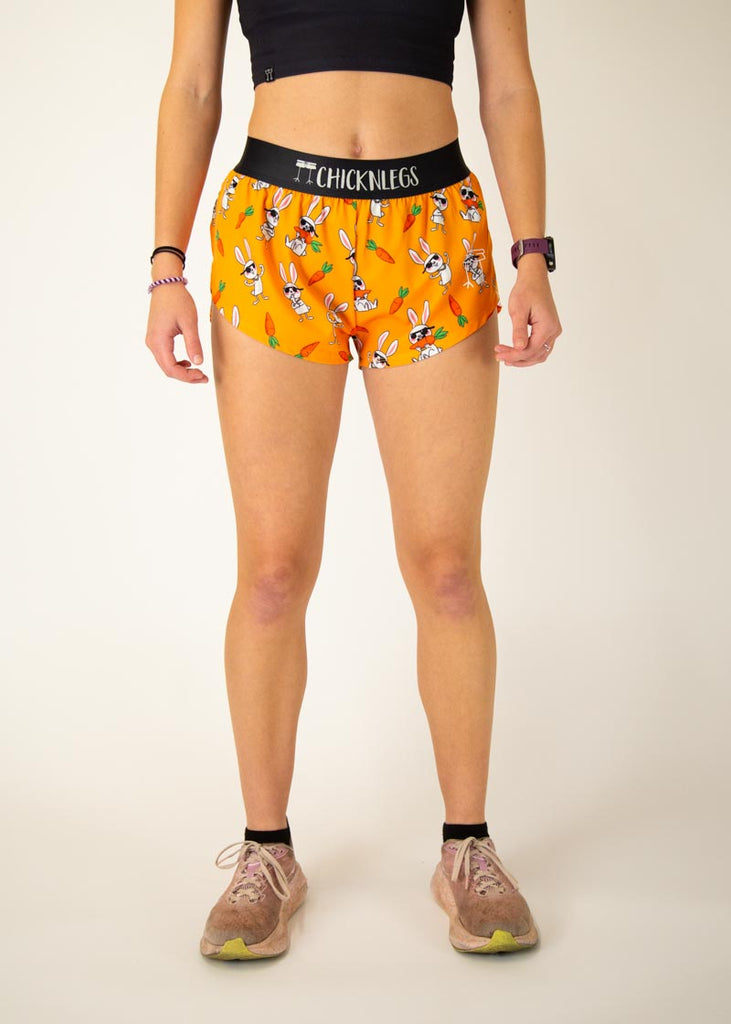 Runner is wearing ChicknLegs in the women's 1.5 in split running shorts with the bad bunny design. The print has white rabbits on it with sunglasses and carrots.