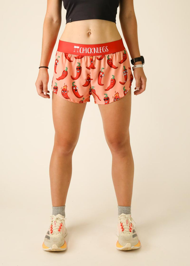 Model is wearing Chicknlegs women's 1.5 inch split running shorts in the chase pack chili pepper design, facing front.