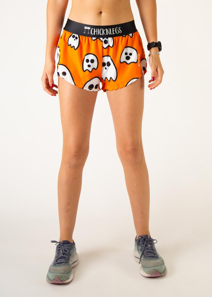 The model is a runner wearing Chicknlegs women's 1.5 inch split running shorts in the Ghosts design, facing front.