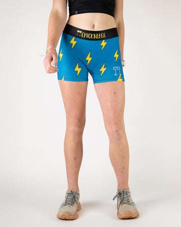 Runner is wearing ChicknLegs in the women's 3 in compression spandex shorts in the blue bolts design. The print has yellow lightning bolts on it with a blue background.