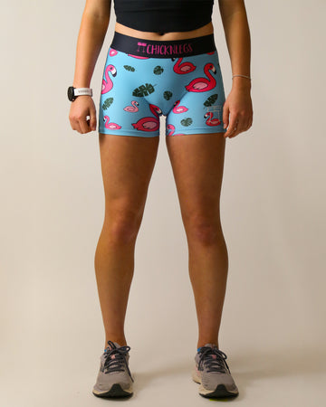 Runner is wearing ChicknLegs women's 3 in compression spandex in the blue flamingo design. The print has pink flamingos on it with green leaves on a blue background.