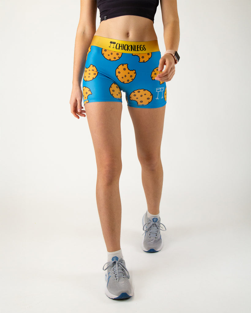 Runner is wearing Chicknlegs in the women's 3 in compression spandex in the cookies design. The print has chocolate chip cookies on it with a blue background.