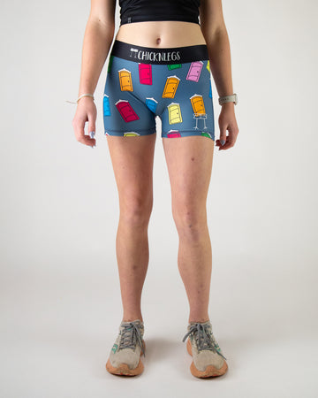 Runner is wearing ChicknLegs women's 3 in compression spandex shorts in the porta potty design. The print has porta pottys on it in red, orange, yellow, blue, pink and green.