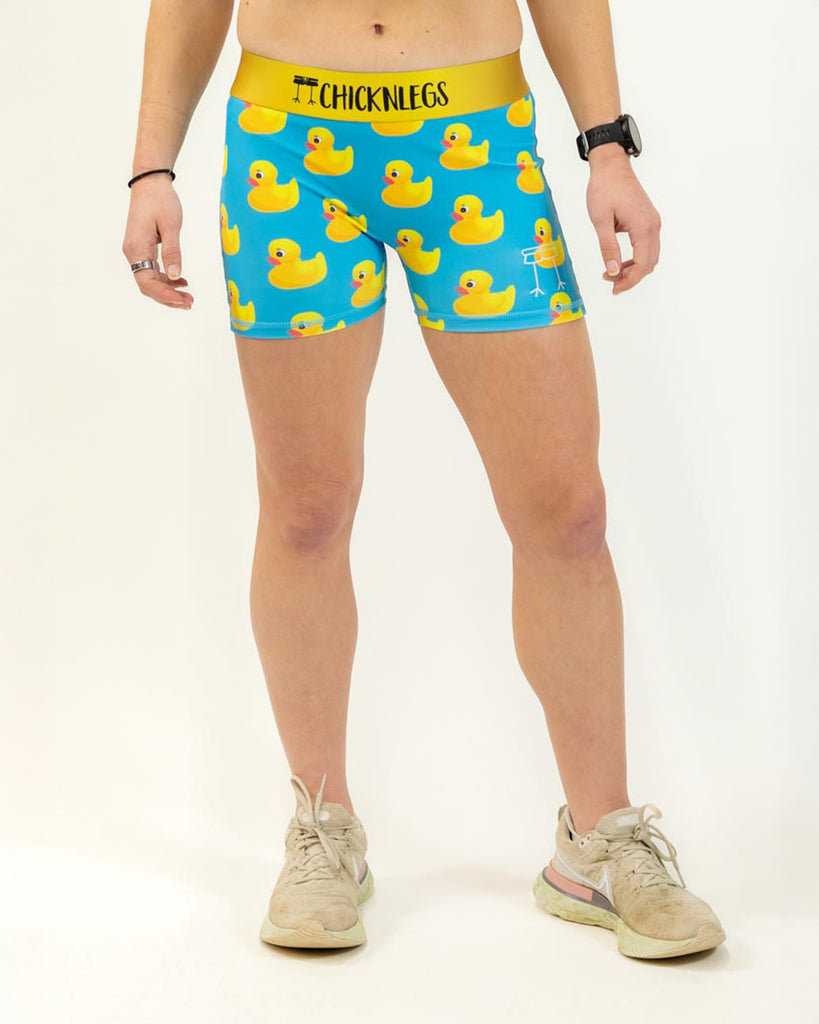 Runner is wearing ChicknLegs in the women's 3 in compression spandex shorts in the rubber ducky design. The print has yellow ducks on it with a blue background.