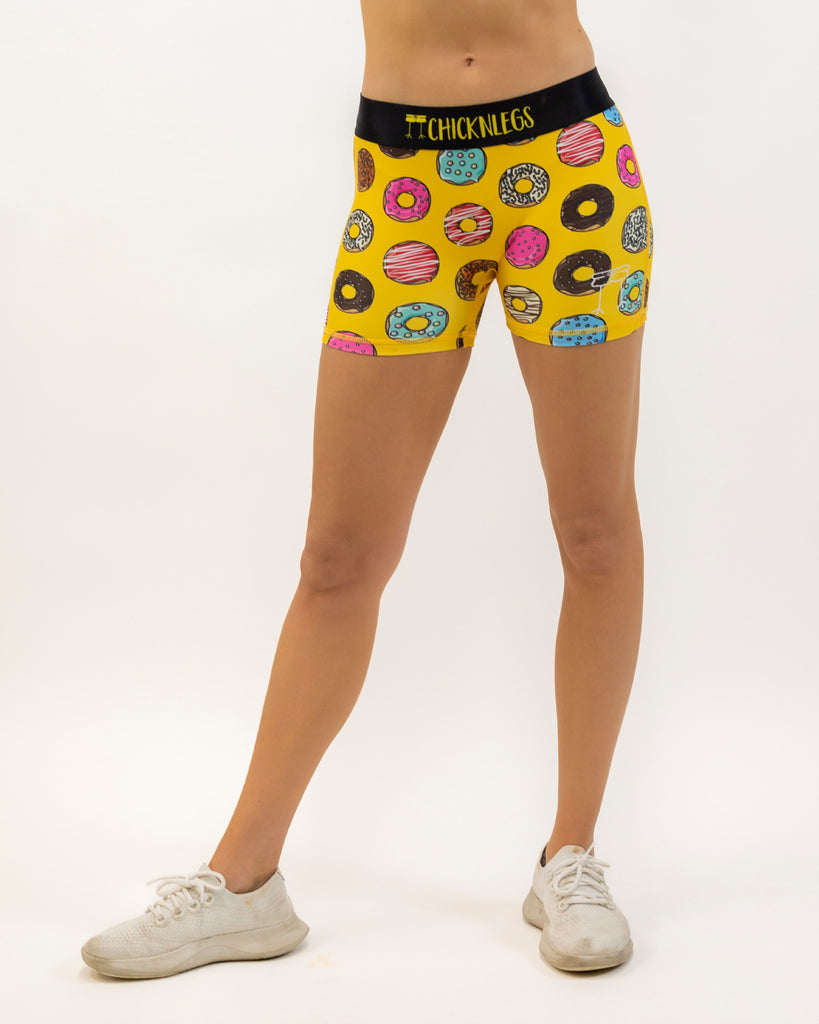 Runner is wearing ChicknLegs women's 3 in compression spandex in the salty donuts design. The print has fun doughnuts over it in many flavors.