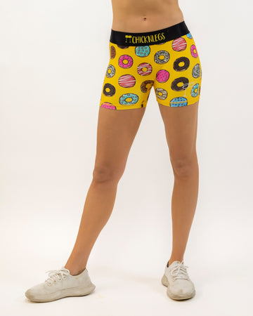 Runner is wearing ChicknLegs women's 3 in compression spandex in the salty donuts design. The print has fun doughnuts over it in many flavors.