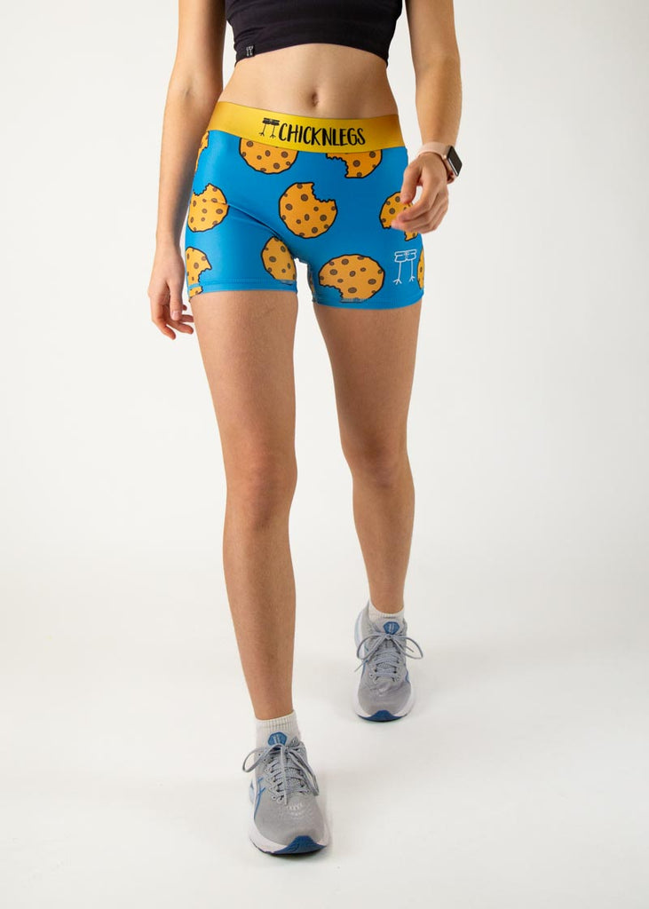 The model is a runner who is wearing Chicknlegs women's 3" compression shorts in the cookies design, facing front.