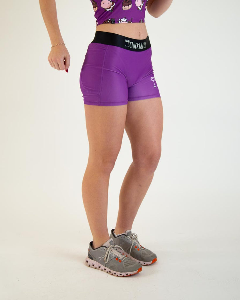 Runner is wearing ChicknLegs in the women's 3 in compression spandex with pockets for shorts in the solid deep purple design.