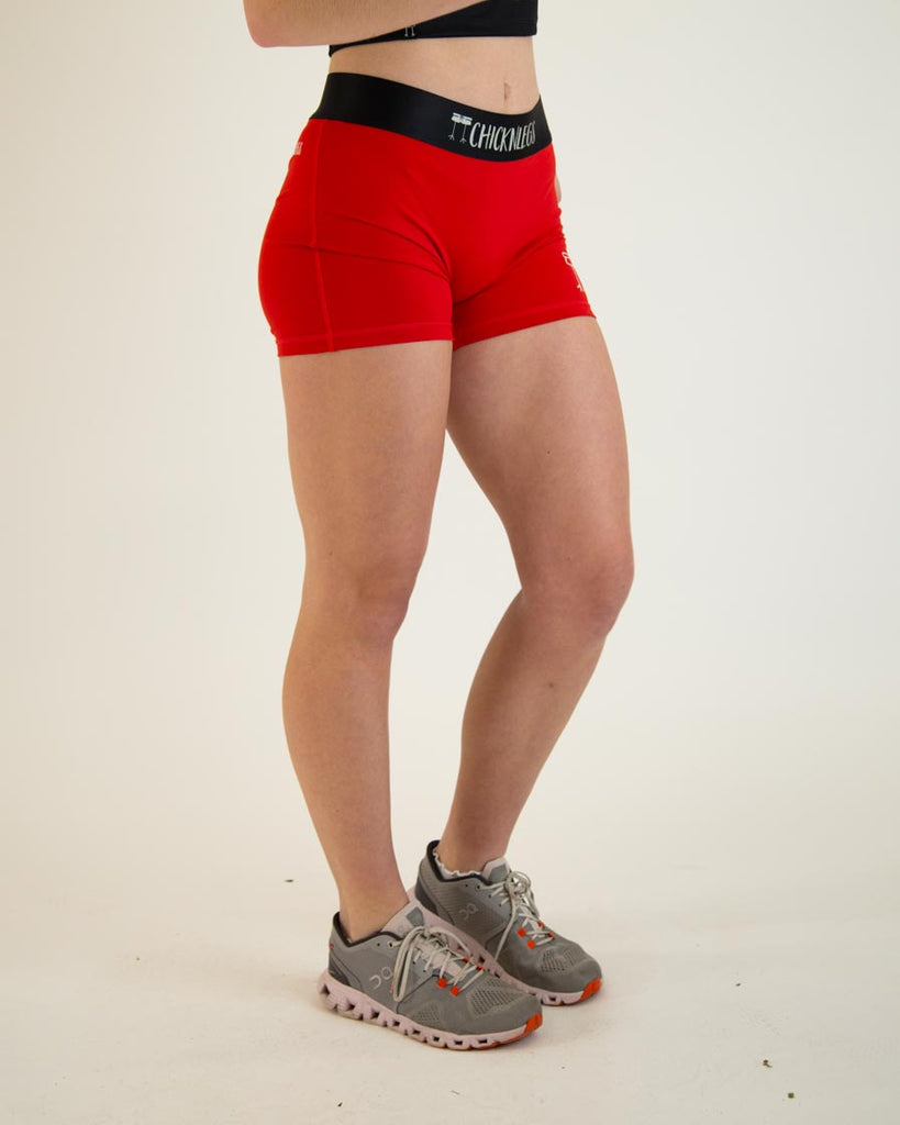 Runner is wearing ChicknLegs in the women's 3 in compression spandex shorts in the solid red design with no pockets. Bright red to stand out like a stop sign.