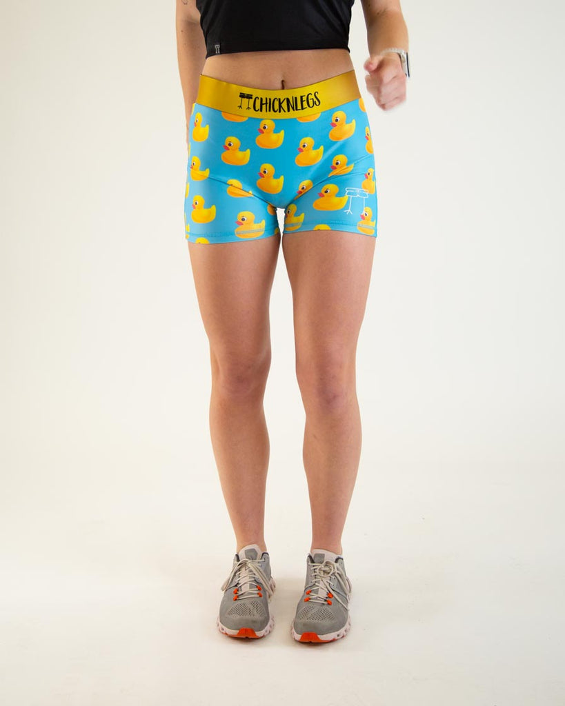 Runner is wearing ChicknLegs in the women's 3 in compression spandex shorts with no pockets. The print has yellow rubber ducky on it with a blue background.