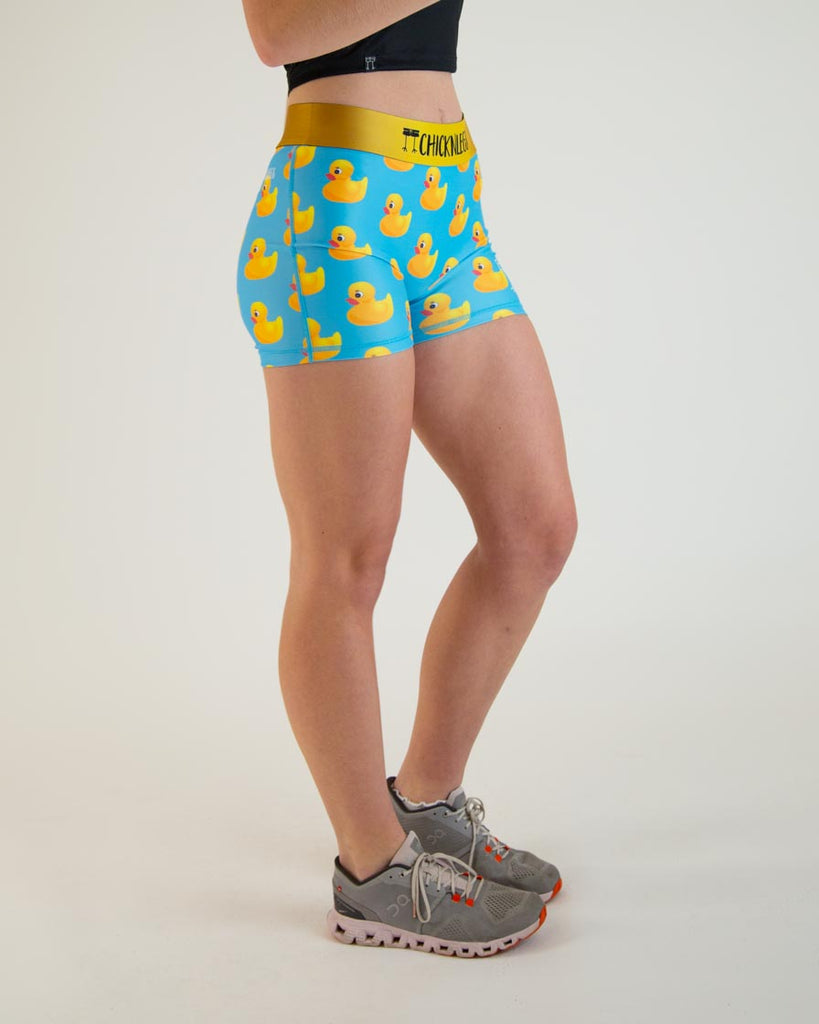 Runner is wearing ChicknLegs in the women's 3 in compression spandex shorts with no pockets. The print has yellow rubber ducks on it with a blue background.