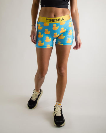 Runner is wearing ChicknLegs in the women's 3 in compression spandex shorts with pockets in the rubber ducky design. The print has yellow rubber ducks on it with a blue background. The model is facing front.