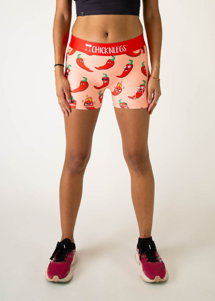 Model is a runner wearing Chicknlegs women's 3 inch compression shorts in the chili pepper design, facing front.