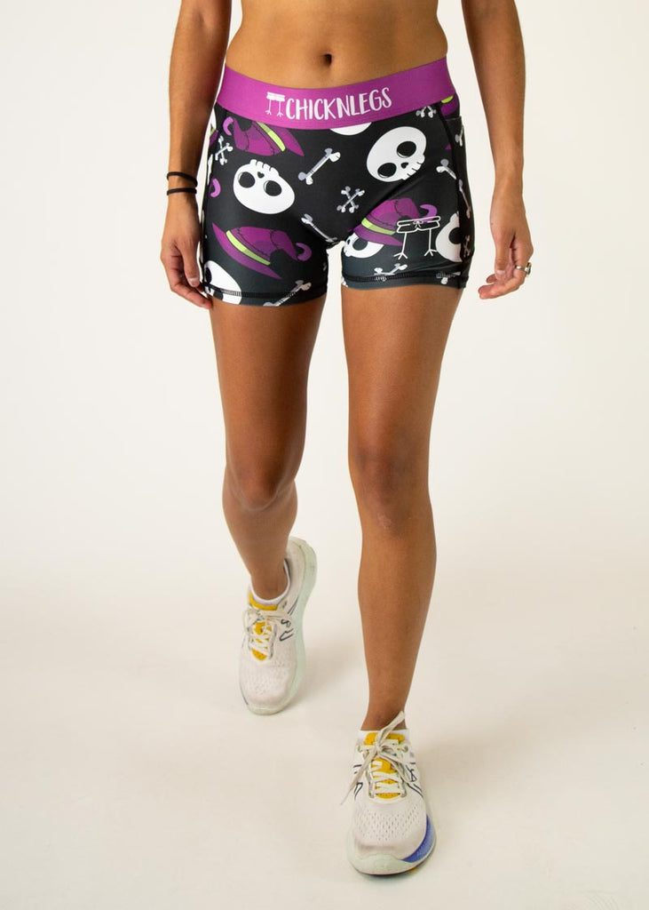 The model is a runner wearing Chicknlegs in women's 3 inch compression shorts in the skulls design, facing front.