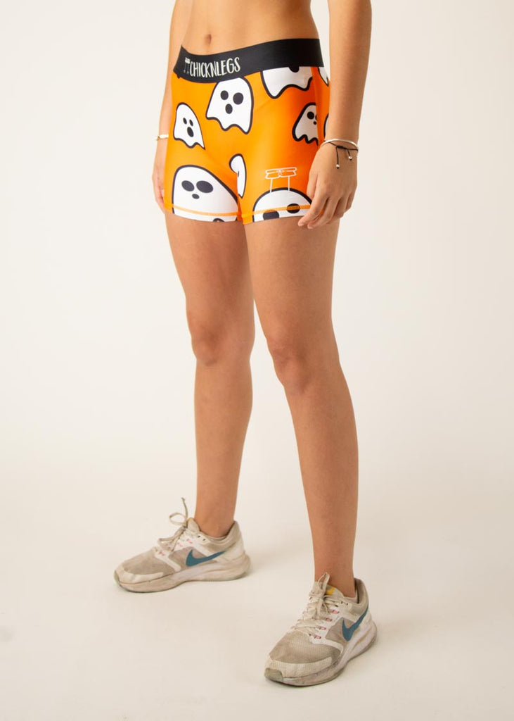 Model is a runner wearing Chicknlegs women's 3" compression shorts in the Ghost design, facing left.