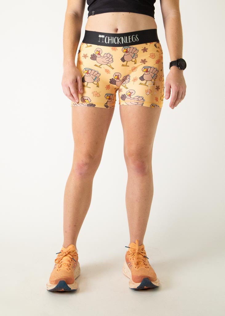 The model is a runner who is wearing Chicknlegs women's 3 inch compression shorts in the pardoned turkey design, facing front.