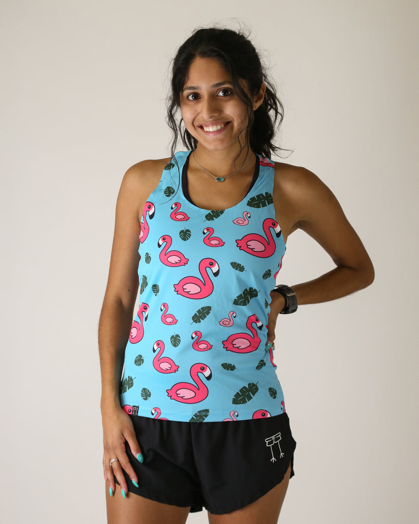 Runner is wearing ChicknLegs in the women's performance singlet in the blue flamingo design. The print has pink flamingos on it with green leaves and a blue background.