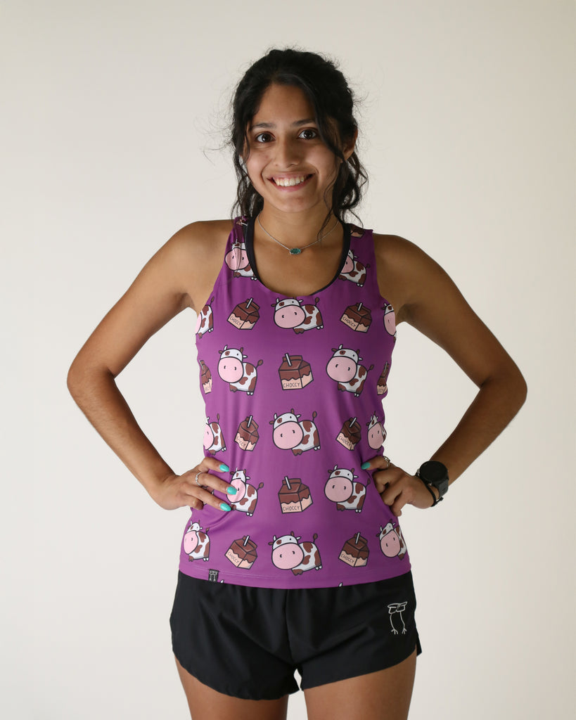 Runner is wearing ChicknLegs in the women's performance singlet in the choccy cow design. The print has brown cows on it with chocolate milk and a purple background.