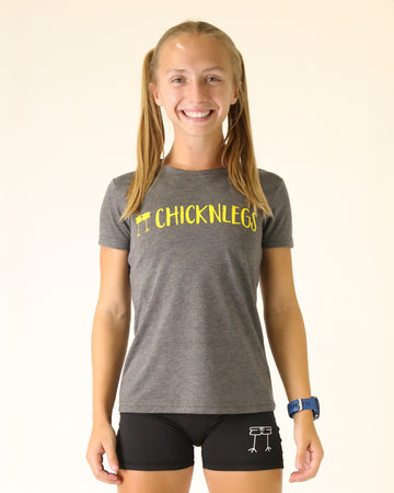 Runner is wearing ChicknLegs Graphic Tee Shirt in the heather grey gray color with the yellow logo across the chest.