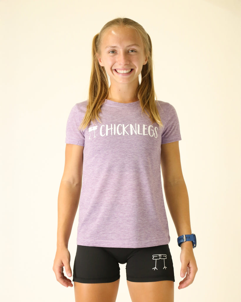 Runner is wearing ChicknLegs in the women's graphic tee shirt in the heather purple with a white chicknlegs logo.