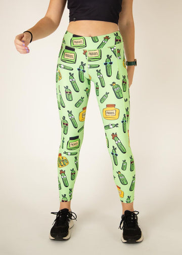 The model is a runner who is wearing Chicknlegs Women's Leggings in the Pickles design. These leggings include side pockets and an adjustable drawstring at the front. The model is facing front.