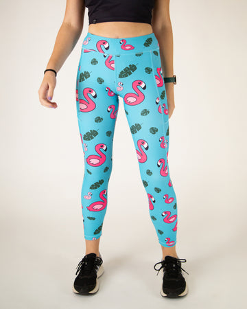 Runner is wearing ChicknLegs in the women's drawstring leggings with pockets in the blue flamingo design. The print has pink flamingos with green leaves on a blue background.