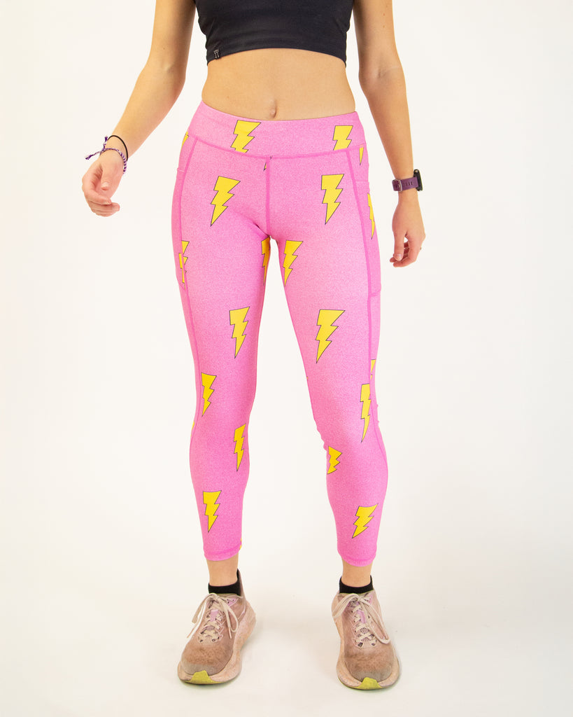 Runner is wearing ChicknLegs in the women's drawstring leggings with pockets in the hot pink bolts design. The print has yellow lightning bolts on a hot pink background.