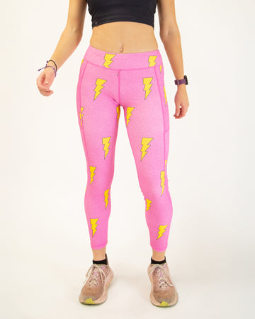 Runner is wearing ChicknLegs in the women's drawstring leggings with pockets in the hot pink bolts design. The print has yellow lightning bolts on a hot pink background.