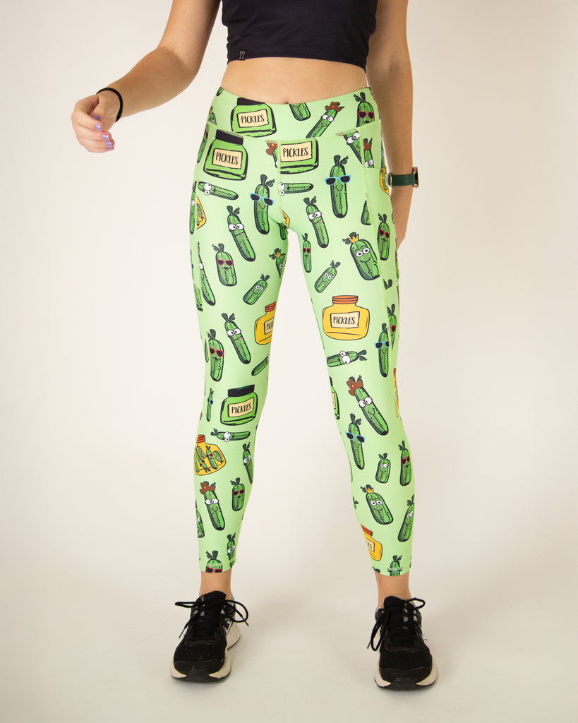 Runner is wearing ChicknLegs in the women's drawstring leggings with pockets in the pickles design. The print has pickles in different shapes and sizes in yellow and green jars.