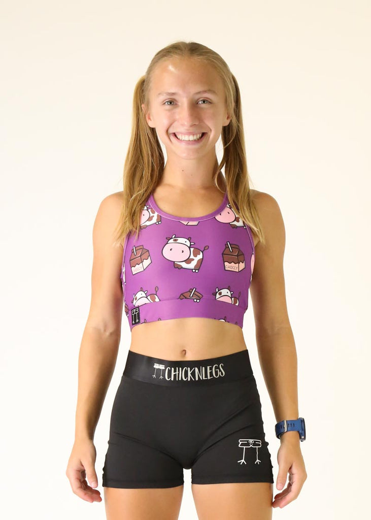 Model wearing Chicknlegs OG Sports Bra in the choccy cows design facing front.