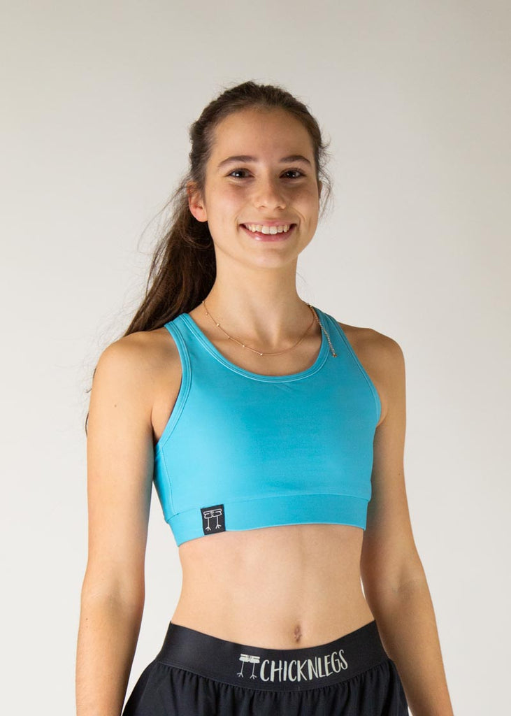 The model is a runner who is wearing Chicknlegs in the women's OG sports bra in the sky blue design, facing front. A close up image is shown of the model.