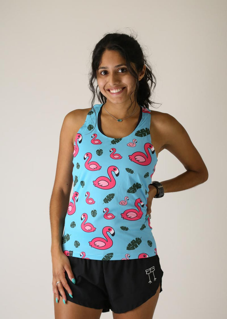 Model wearing Chicknlegs women's performance singlet in the blue flamingo design front view.