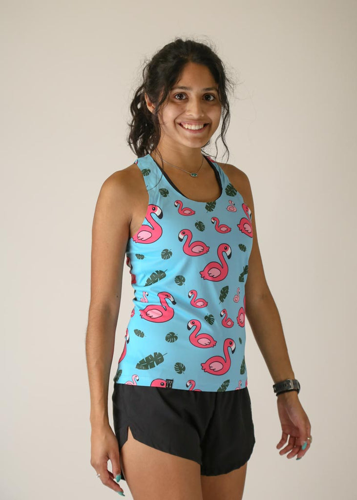 Model wearing Chicknlegs women's performance singlet in the blue flamingo design right side view.