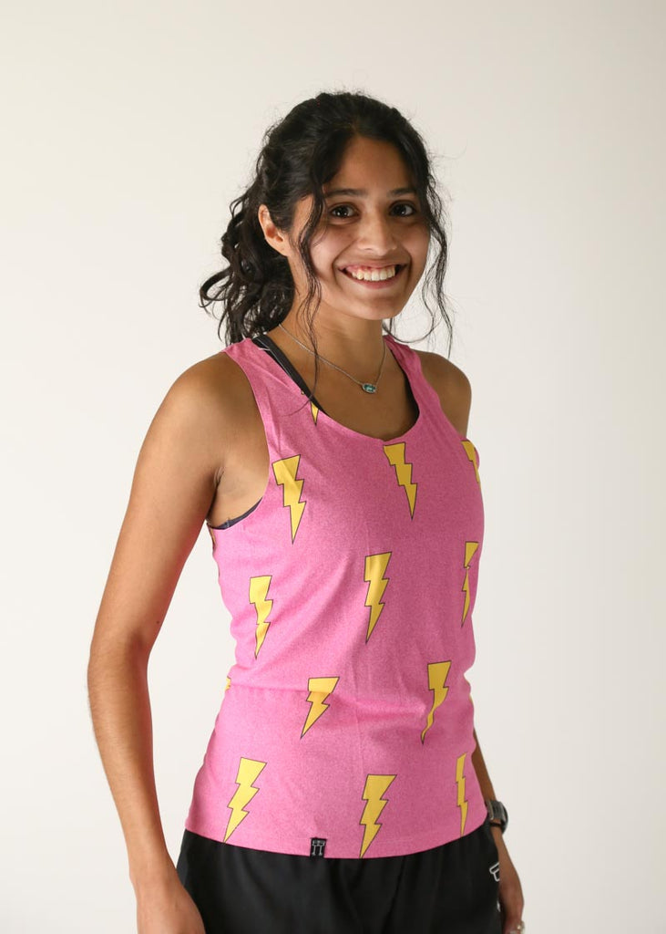 Model wearing Chicknlegs women's performance singlet in the hot pink bolts design right side view.