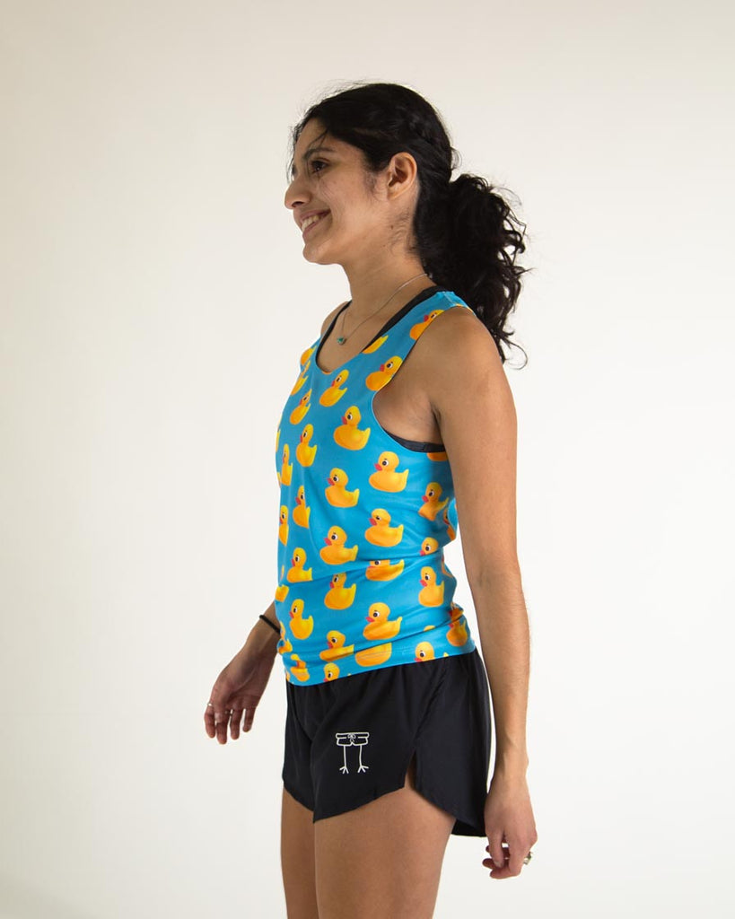 Runner is wearing ChicknLegs in the men's performance rubber ducky singlet. The print has yellow rubber ducks on it with a blue background. The model is facing left.