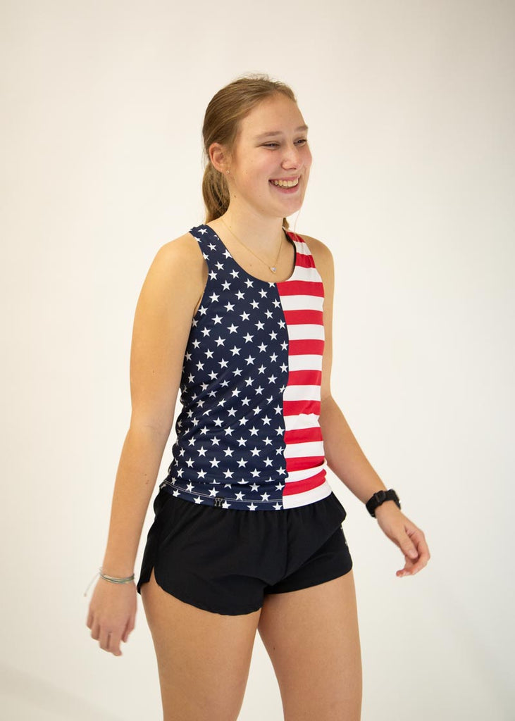 The model is a runner who is wearing Chicknlegs women's singlet in the USA design, facing right.