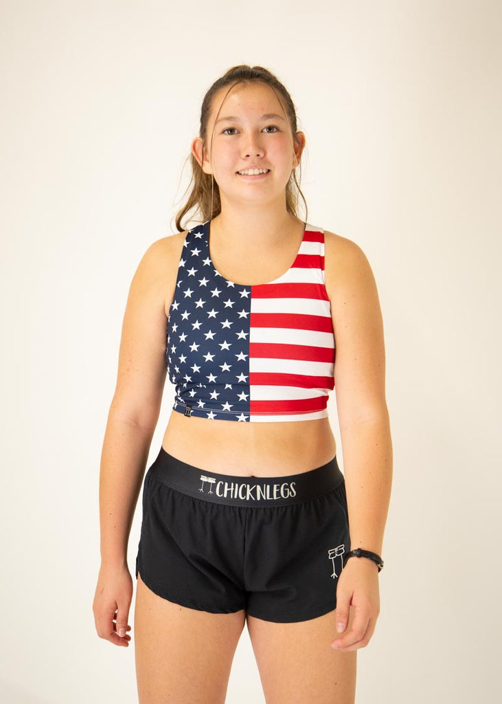 The model is a runner who is wearing Chicknlegs women's pwr USA crop top, facing front.