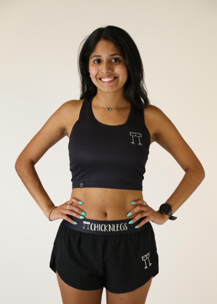 Front view of runner wearing the women's black PWR crop top from ChicknLegs.