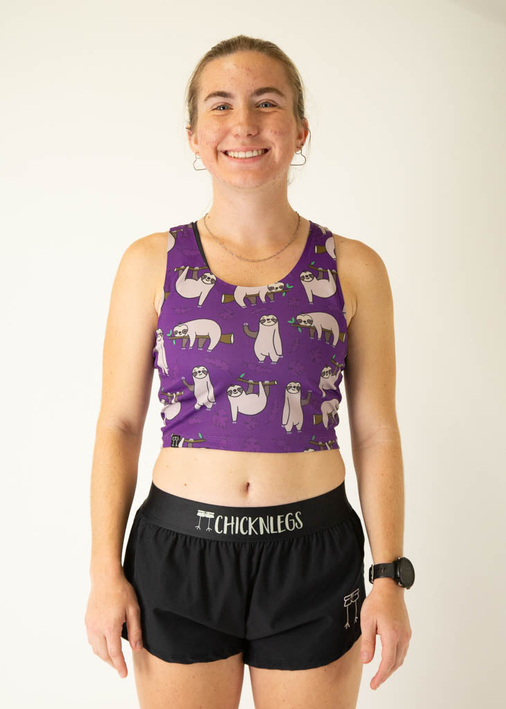 The model is a runner who is wearing Chicknlegs PWR crop top in the sloths design, facing front.