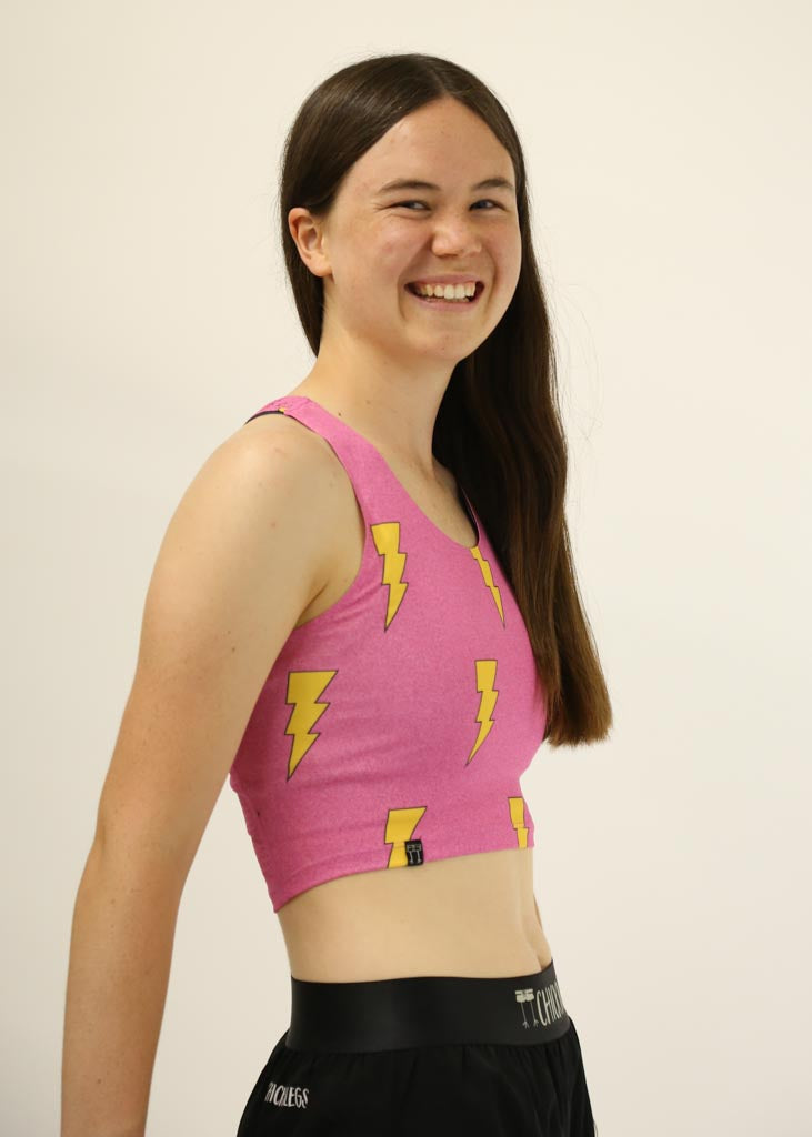 Side view of runner wearing the pink bolts PWR crop top.