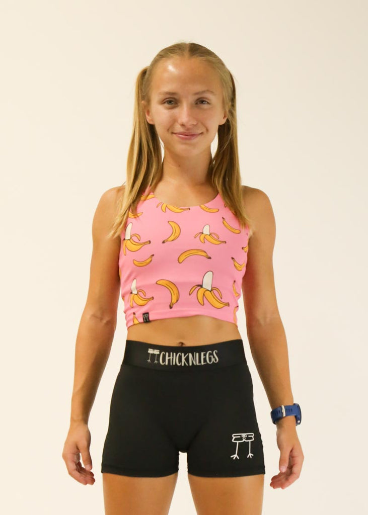 Model is wearing Chicknlegs PWR crop top in the pink bananas design facing front.