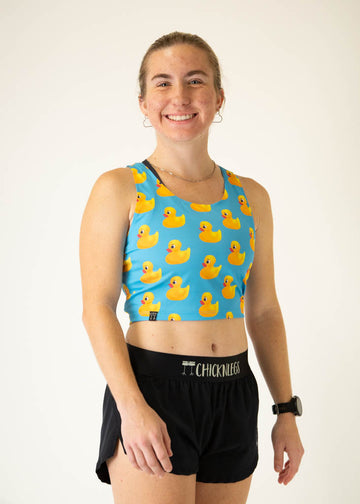 The model is a runner who is wearing Chicknlegs PWR crop top, in the rubber ducky design, facing right.